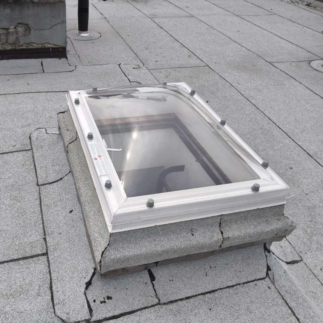 Nieuwe heldere lichtkoepel geplaatst op bestaande gemetselde opstand op plat dak