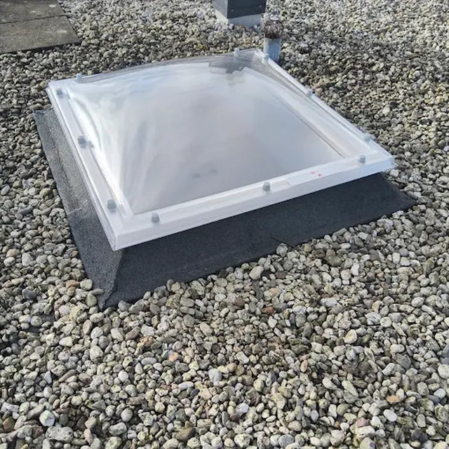 Lichtkoepel op een plat dak met grind